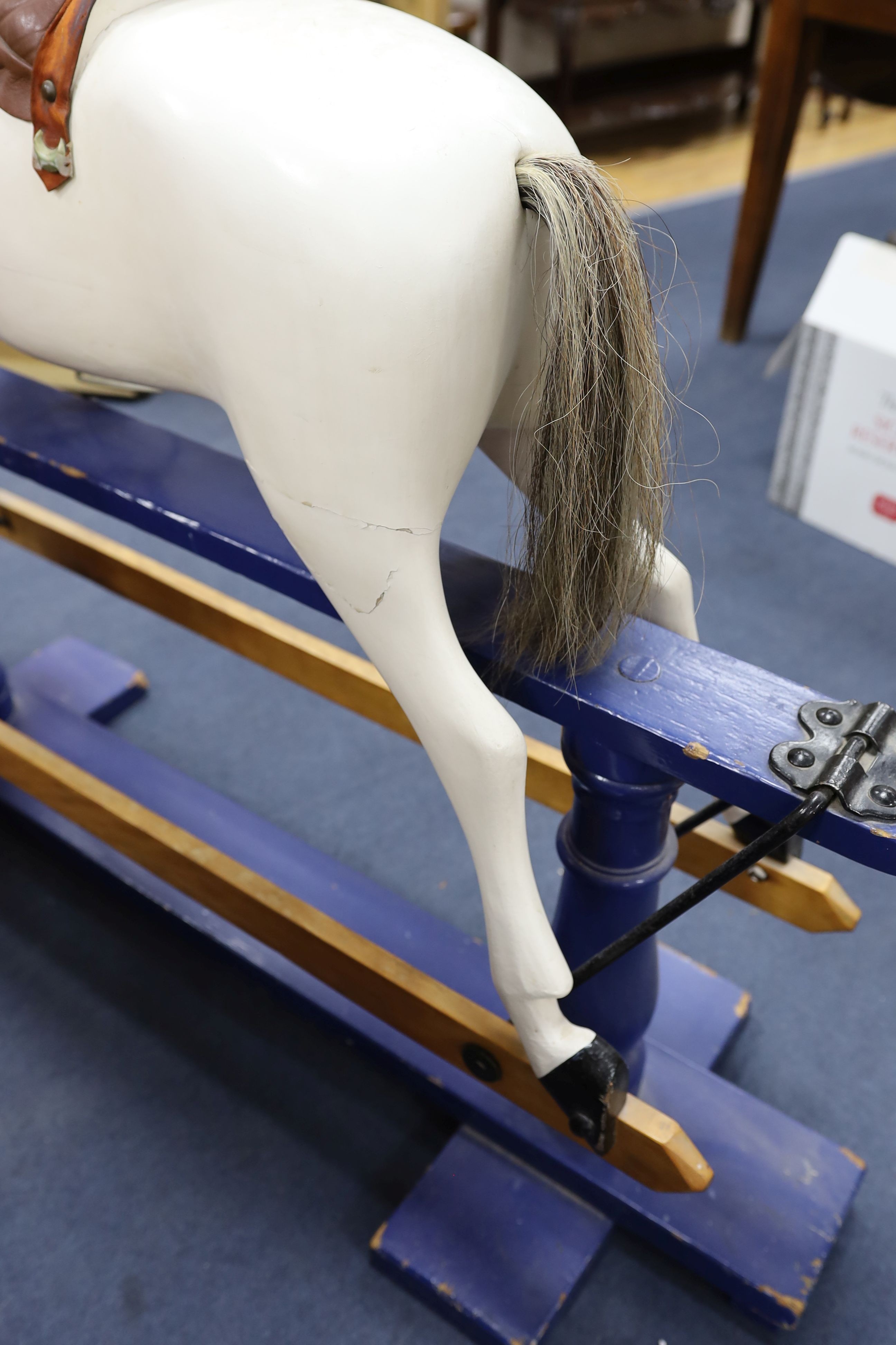 An early 20th century rocking horse on painted safety frame, (re-painted) width 126cm, height 114cm